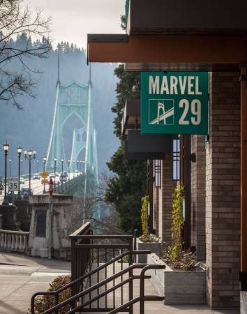 A green sign with white text that reads "MARVEL 29" is hanging on a building.